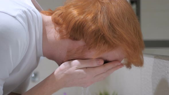 Man Washing Face in Sink, Bathroom