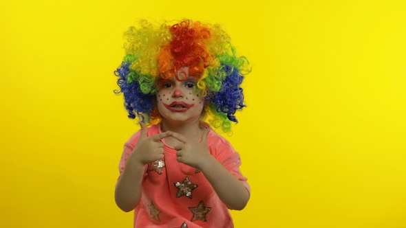 Little Child Girl Clown in Wig Making Silly Faces, Singing, Making Shot Signs From Hands, Halloween