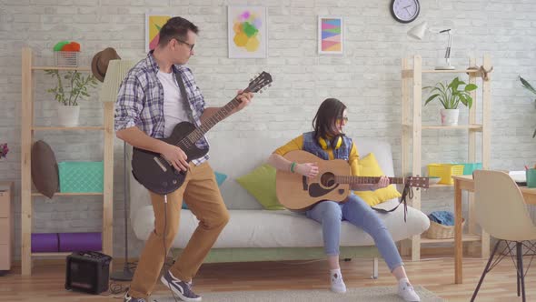 Young Woman and a Young Man Emotionally Playing the Guitar