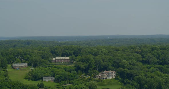 Backwards Aerial Pan Luxury Mansions Amongst Trees in Cold Spring Harbor