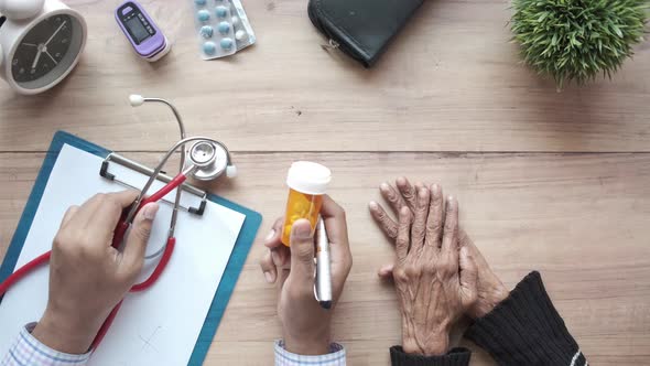 Doctor Giving a Medical Pill Container His Senior Patient