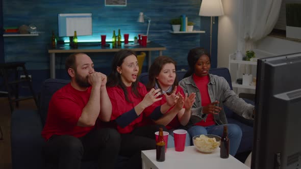 Mixed Race Group of People Watching at Football Game on Television Cheering Sport Team