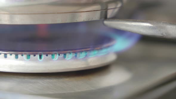close up shot of a person turning on a stove then turning it off. the stove is in a metallic grey co