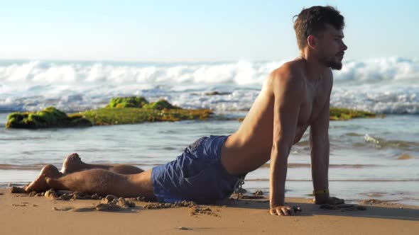 Muscular Man with Beard Breathes Deeply in Yoga Position