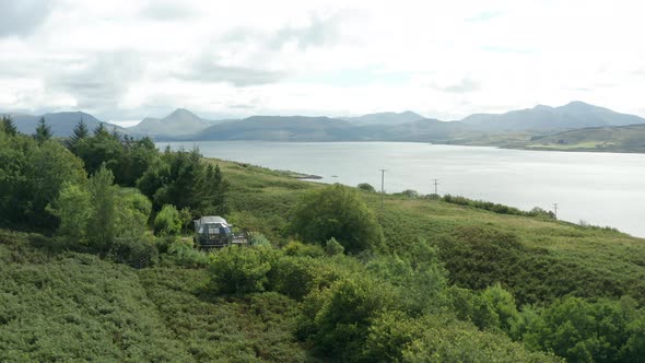 AERIAL APPROACH- A modern aluminium cabin home during summer in Scotland