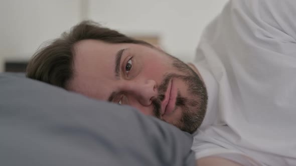 Portrait of Young Man Awake in Bed Thinking