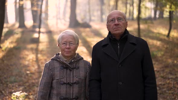 Aged Couple Posing During Walk in Autumn Park