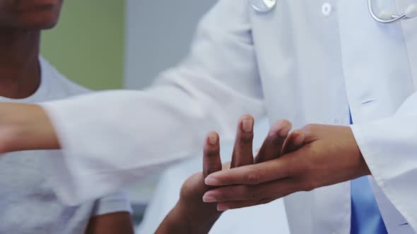 Close-up of African american female doctor checking sugar level of male patient in hospital ward