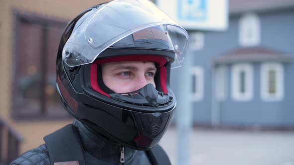 Side view of a biker in a helmet with an open visor.