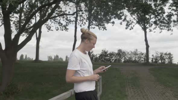 A Close up of a Young Woman Eating and Playing on her Phone in the Dutch Countryside