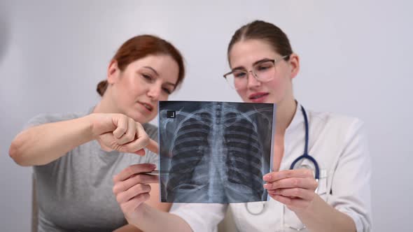 The Doctor Consults a Caucasian Woman and Comments on the Xray of the Lungs