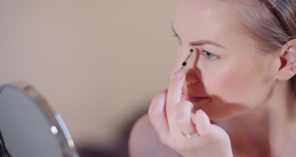 Woman Doing Makeup Painting Eyelashes with Mascara