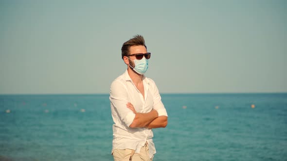 Sad Man In Face Mask At Covid Looking On Sea New Normal. Lockdown On Vacation. Covid-19 Pandemic