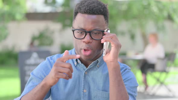 Portrait of Angry African Man Talking on Smartphone