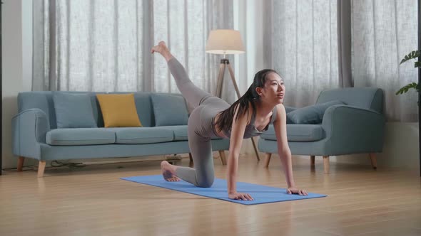 Asian Athletic Female Exercising, Stretching And Practicing Yoga At Home. Healthy Lifestyle