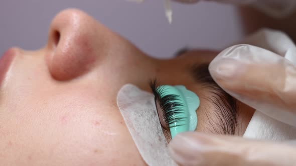 The Master Combs the Eyelashes of a Woman with a Fish Applicator