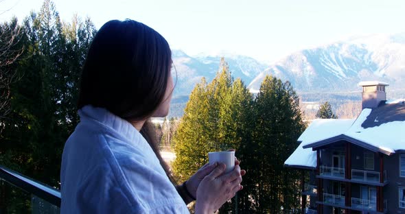 Woman having a cup of coffee in balcony