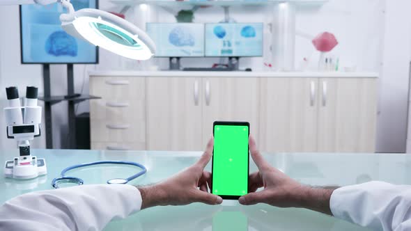 Male Hands Holding a Phone with Green Screen Mockup