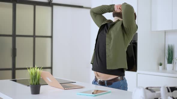 Stressed Caucasian Man Messaging Online on Laptop and Holding Head in Hands