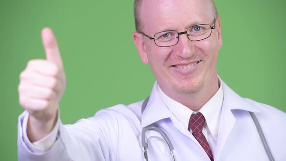 Happy Mature Bald Man Doctor Giving Thumbs Up