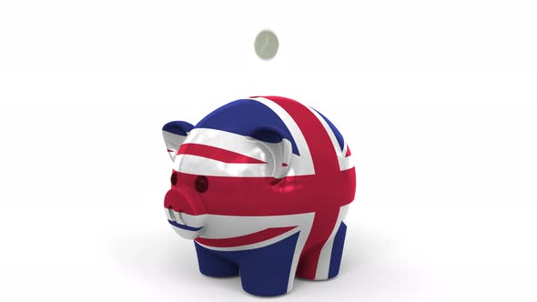 Coins Fall Into Piggy Bank Painted with Flag of Great Britain