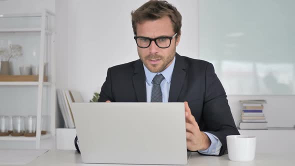 Businessman Reacting to Financial Loss at Work