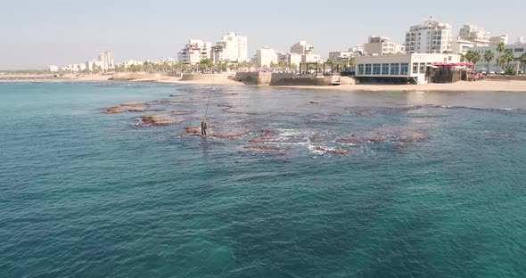 Aerial view of a man fishing in the sea, Acre, Israel.