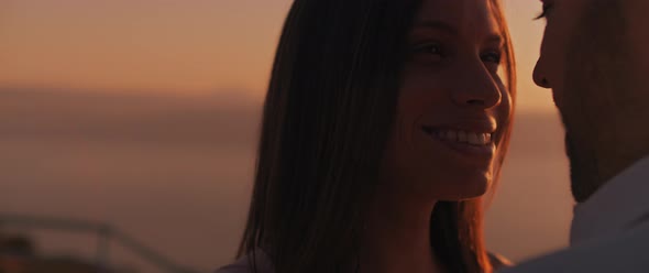 Close up of a young woman looking at her boyfriend with love, smiling, at sunset. Slow motion. 