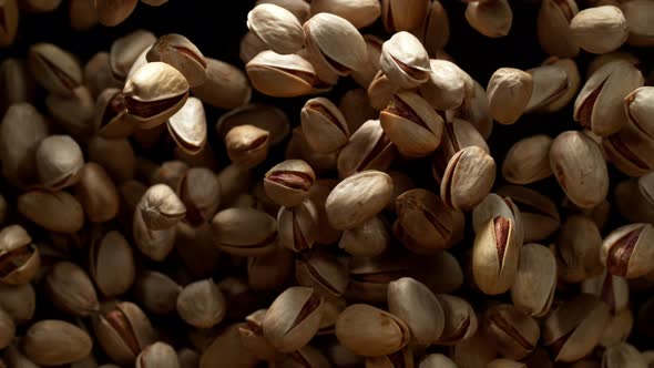 Super Slow Motion Shot of Pistachios Flies After Being Exploded Against Black Background 1000Fps