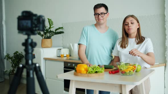 Couple of Blogger Recording Video in Kitchen Showing Thumbs-up Waving Hand