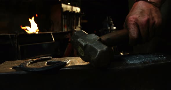 Mid-section of blacksmith holding hammer