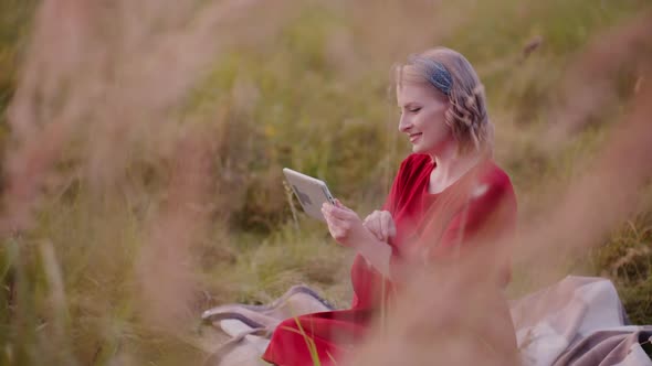 Young Smiling Woman Typing on Digital Tablet Outdoors