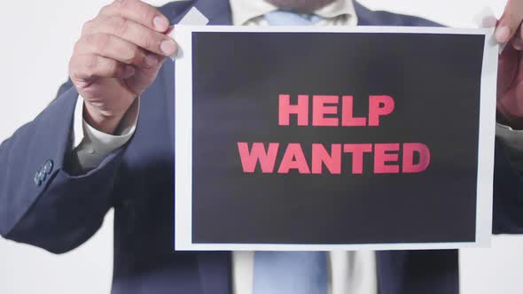 Businessman Posts Sign On Window Help Wanted2