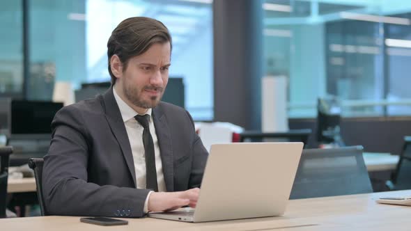 Angry Businessman Working on Laptop in Frustration
