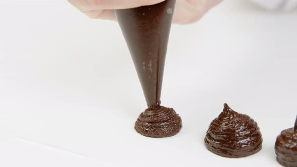 Closeup Confectioner Squeezes Ganache Cream Out of Pastry Bag, Making Truffles