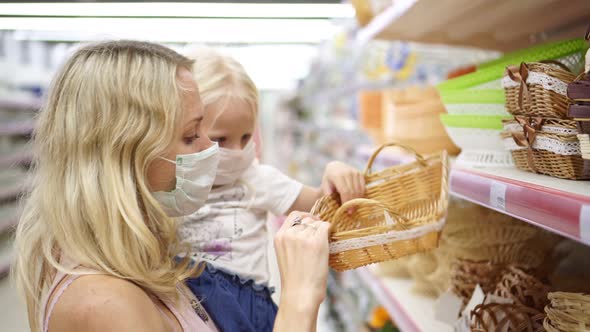 Family, Woman and Child in Medical Masks in the Store Choose Goods