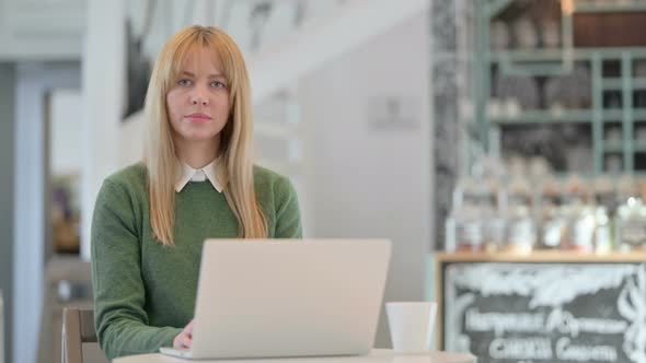 No Gesture with Finger By Young Woman While Working on Laptop in Cafe