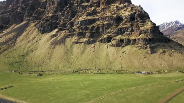 Iceland Farm Fields with jagged Rocky Mountain off of ring road