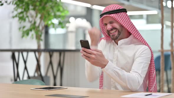 Arab Businessman Celebrating Success on Smartphone