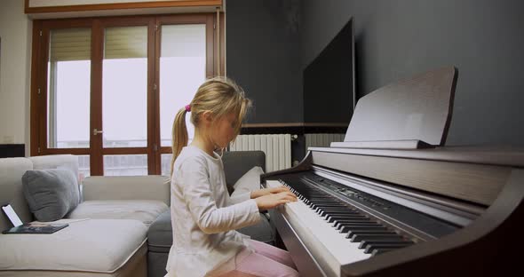 Little Girl Playing Piano at Home. Kid Play Piano in Living Room. Child Learning Piano at Home