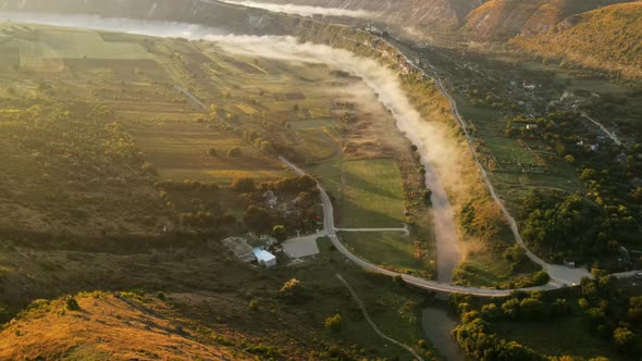 Aerial drone view of the Old Orhei at sunset. Valley with river and fog, village, monastery located 