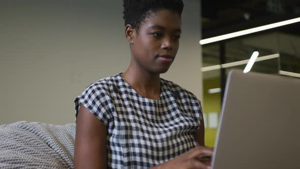 African american businesswoman sitting at desk using laptop in office