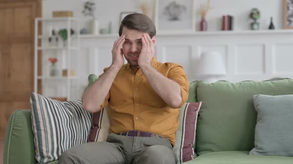 Businessman having Headache while Sitting on Sofa