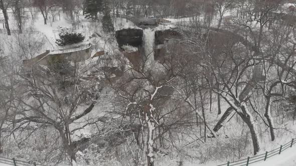 Aerial footage of a winter landscape revealing a waterfall, Minnesota, minehaha, cloudy