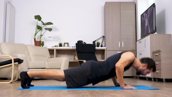 Fit Young Man Doing Push Ups on a Blue Mat