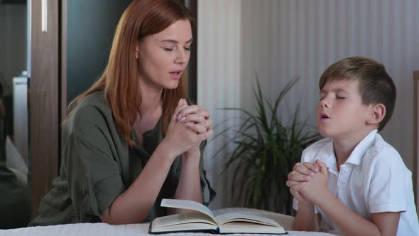Female Parent with Male Child Kneel By Bed with Folded Hands and Pray To God alt