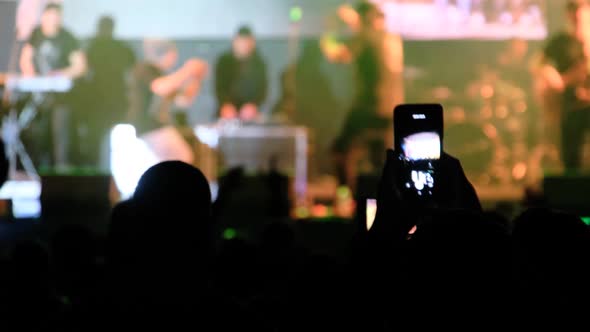 People Filming Rock Concert on Smartphones Silhouettes Crowd of Fans Dancing