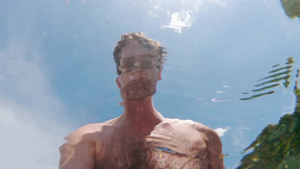 Young White Man Laughing in Sun, Psychedelic Selfie from Low Underwater