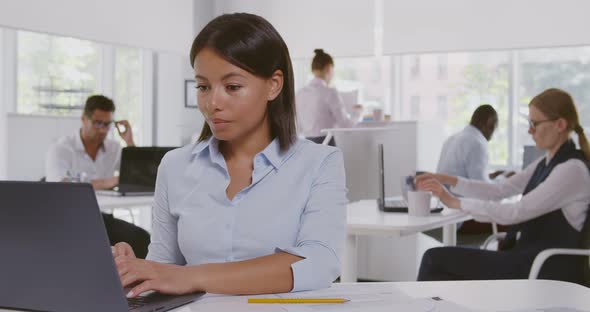 Concentrated African American Businesswoman Sitting at Desk in Office Working on Laptop