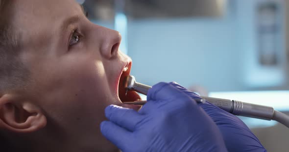 Crop Dentist Drilling Tooth of Boy